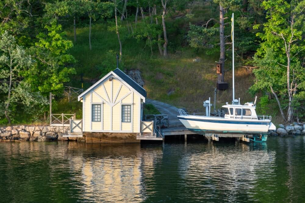 Custom boathouse construction with integrated boat lift system on waterfront home